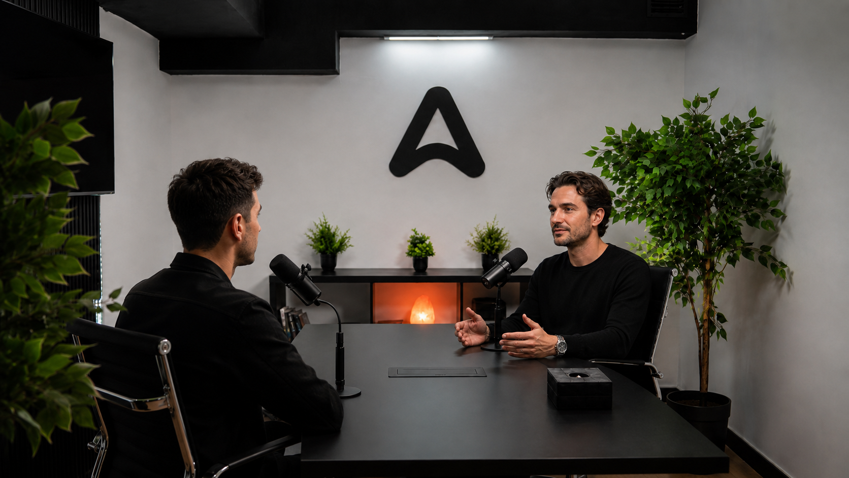 Entrevista de podcast en el estudio de Astia, con dos personas conversando frente a micrófonos profesionales